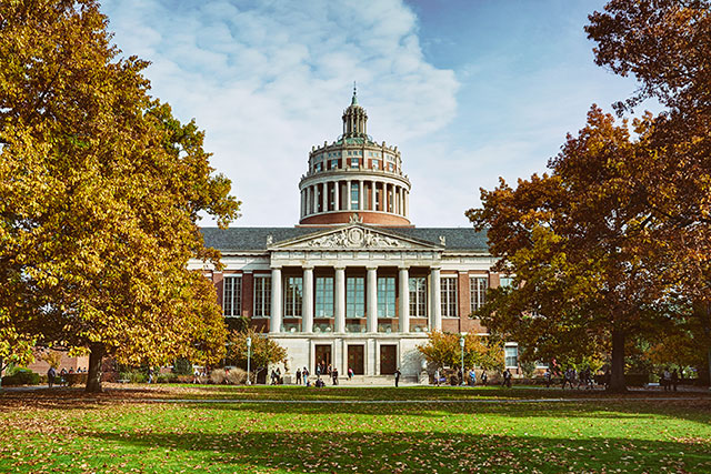 A view of the fron of Rush Rhees Library in autumn from the Eastman Quad.