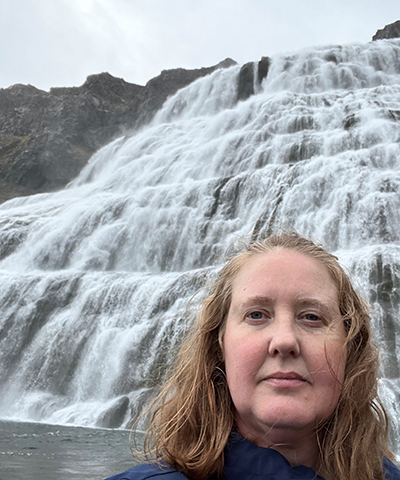 Headhsot of Erin with a waterfall in the background.