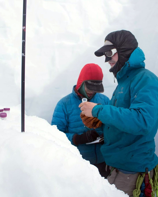 Alex bundled up getting samples from an ice and snow covered area.