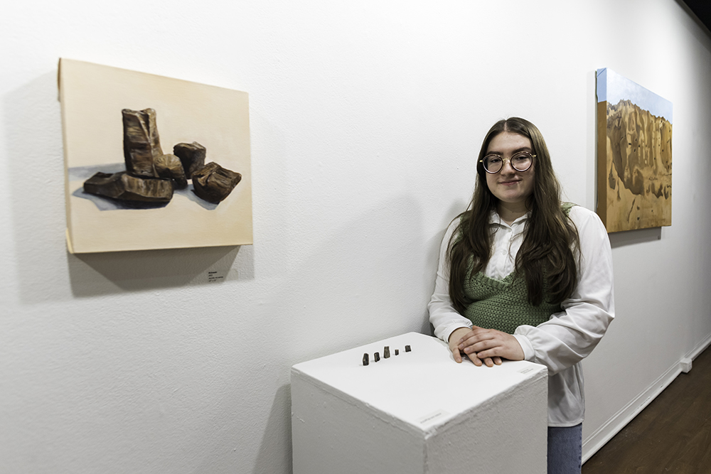 Gabrielle Meli '22, a Geological Sciences and Studio Arts major, is photographed with her art exhibition "Birefringence" in the the Frontispace gallery of the Art and Music Library.