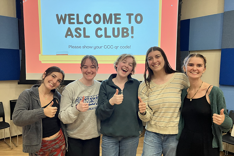 Students posing in front of a screen that says ASL Club.
