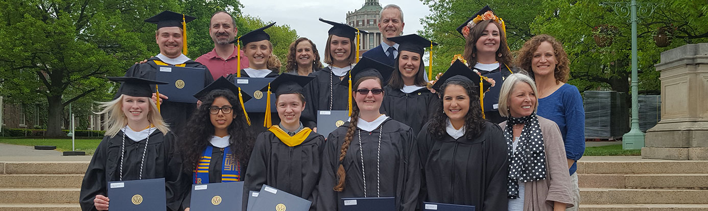 A group smiling at the camera while wearing caps and gowns.