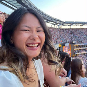 Lucy in a stadium smiling at the camera.