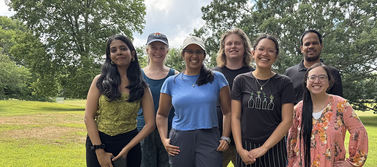 A group of members from 2024 smiling as they pose for the camera in an outdoor setting.
