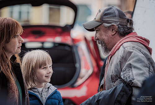 A still image from the movie of a man speaking with a woman and a young boy.