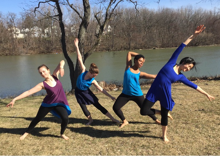 Four dancers holding poses alongside the Genesee River.