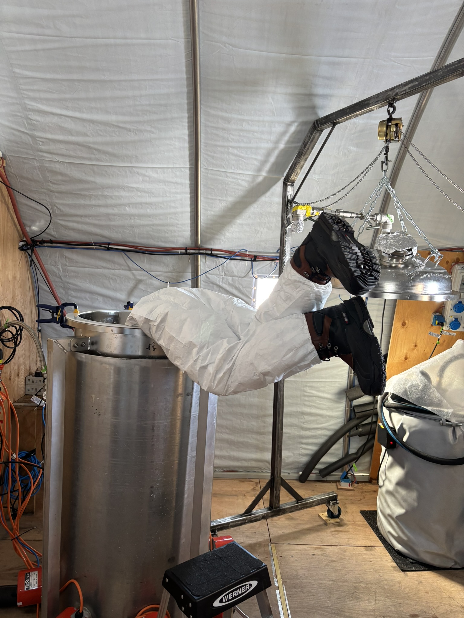 person cleaning the inside of the melter
