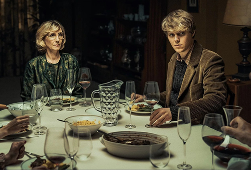 A still image from the film of a man and woman sitting at a dining table.