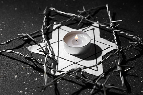 A black and white image of a Star of David with a candle on top.